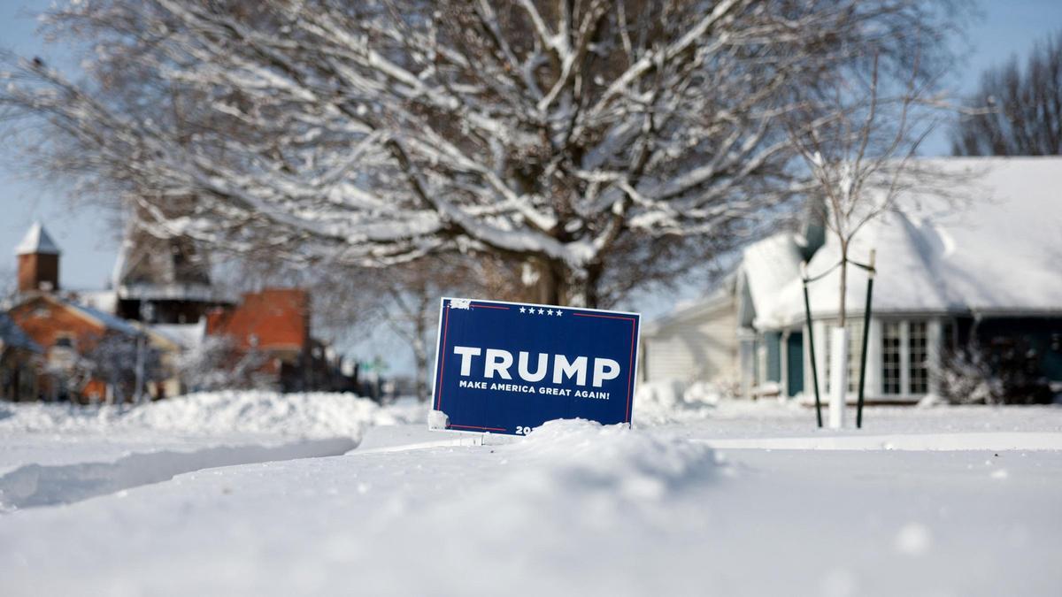 Un cartel de la campaña de Trump para la nominación republicana sobre la nieve en una calle de Pella, Iowa.