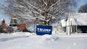 Un cartel de la campaña de Trump para la nominación republicana sobre la nieve en una calle de Pella, Iowa.