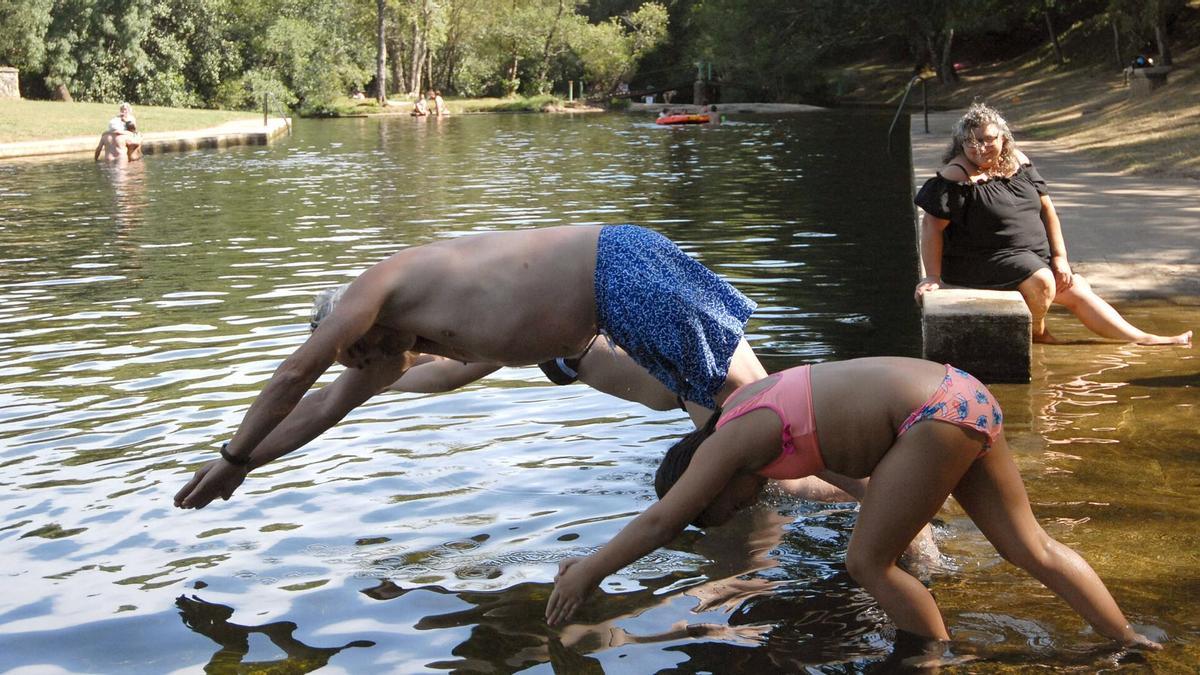 Gente bañándose en la playa fluvial de Vilatuxe.