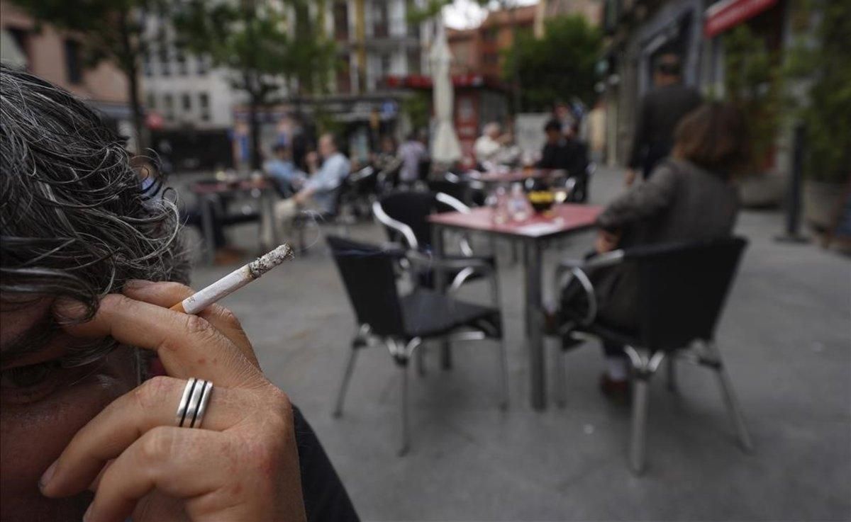 Mujer fumando en una terraza de bar Mujer fumando en una terraza de bar