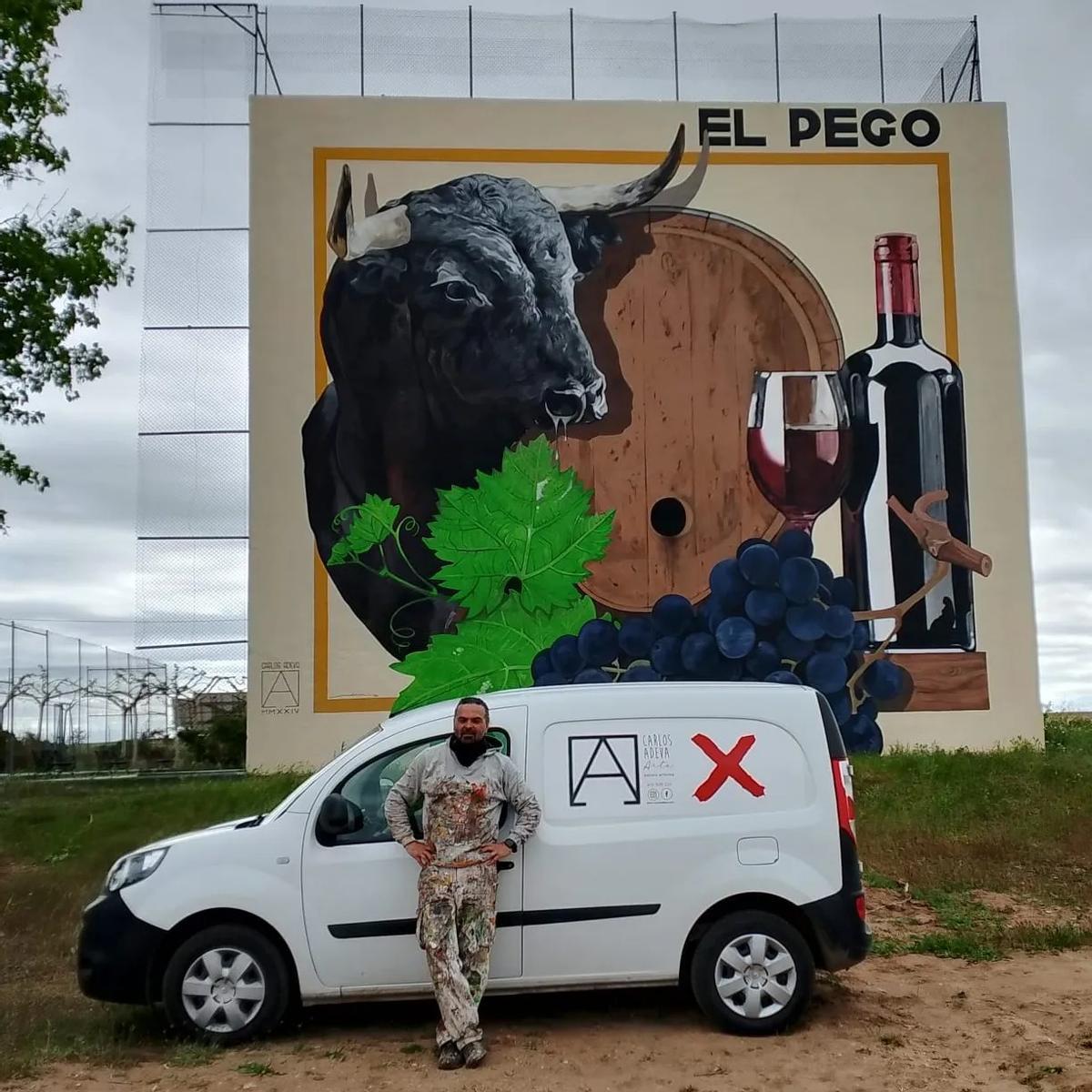 Carlos Adeva posa junto al mural creado en el frontó de El Pego