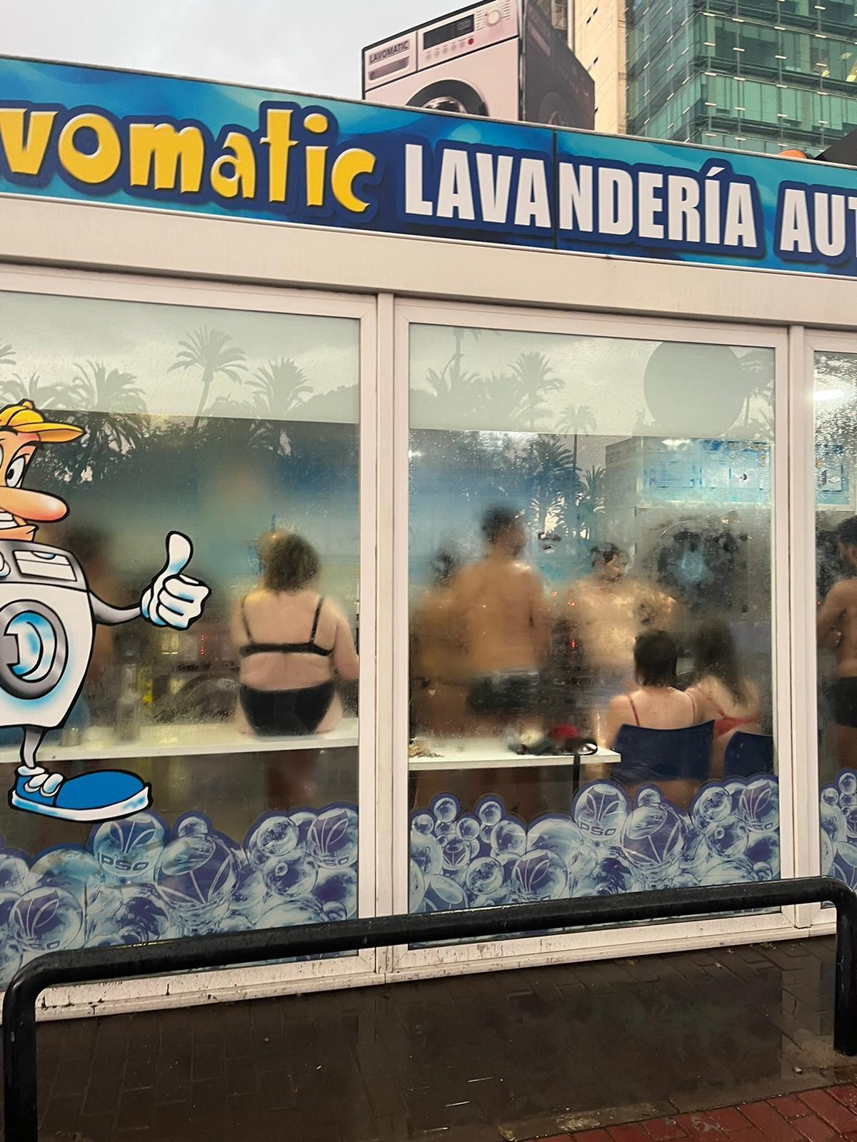 La gente se refugia en una lavandería y aprovecha para secarse la ropa.
