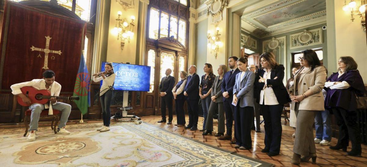 A la izquierda, Adela Gabarri, durante su intervención; a la derecha, vista general de la interpretación del himno «Gelem Gelem» a cargo de Gerson González  y  Anaís González Jiménez. | NACHO VELA