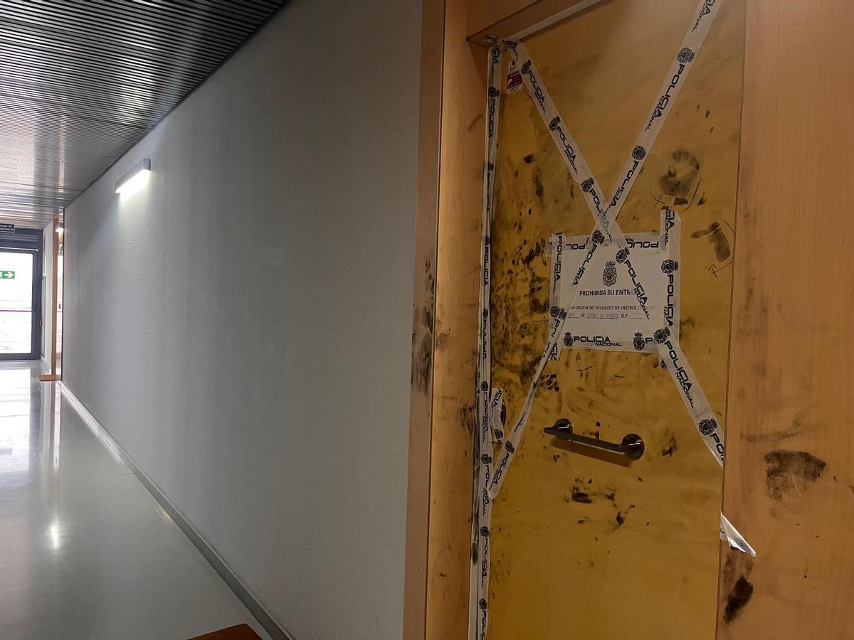 Puerta precintada del apartamento de Manises donde ha sido asesinado José María Ll. Al fondo, la puerta de saida de emergencias a la escalera de incendios.