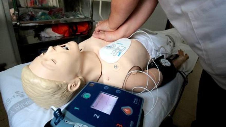 Un médico prueba un desfibrilador en un muñeco de simulación.