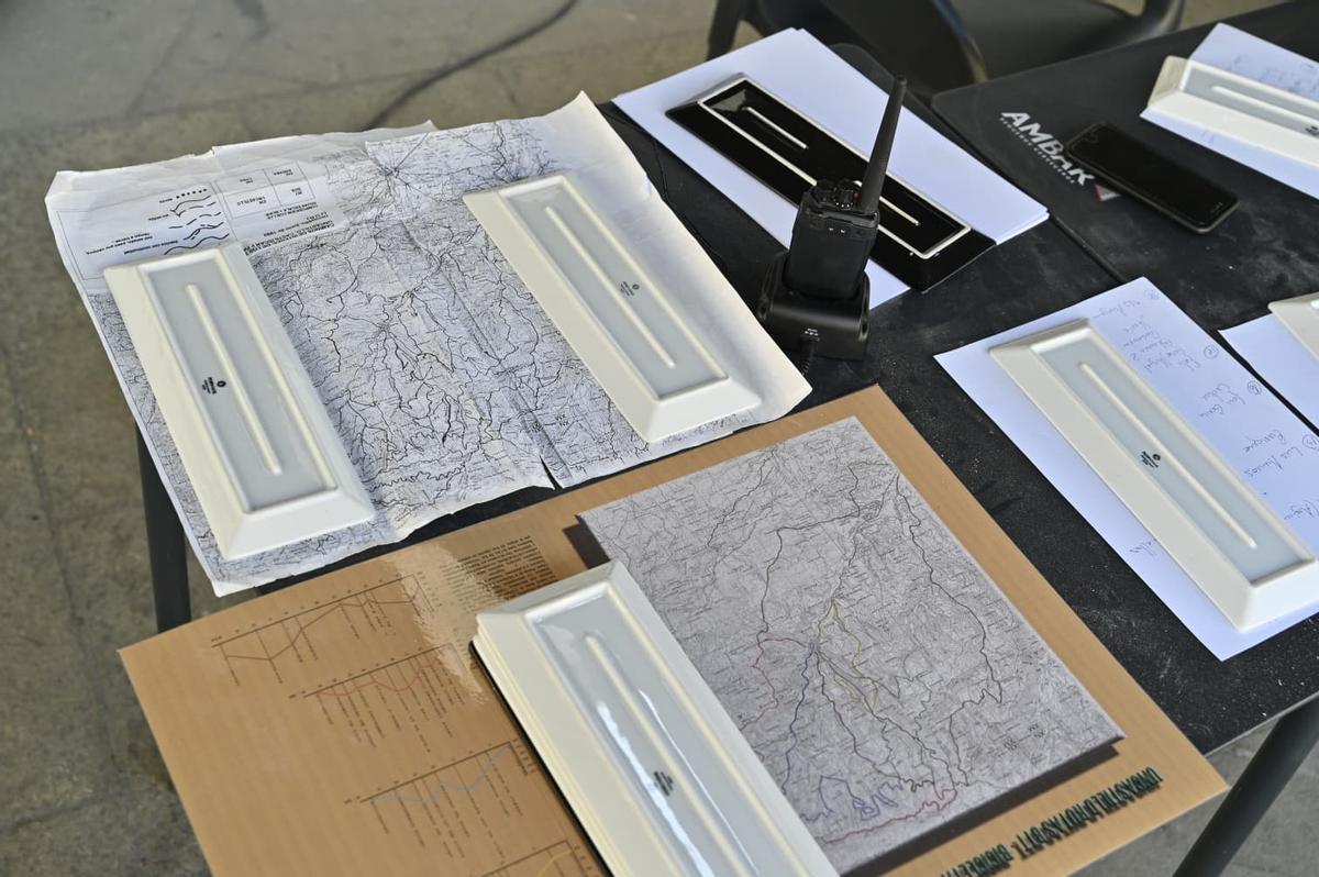 Mapas del monte de Uncastillo, sujetados por platos de raciones, en un céntrico bar de la localidad.