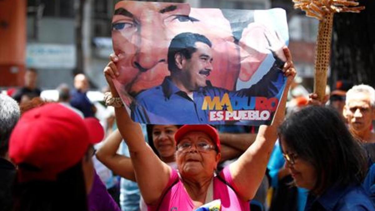 Una mujer, con una pancarta de apoyo a Maduro, el domingo, en Caracas.