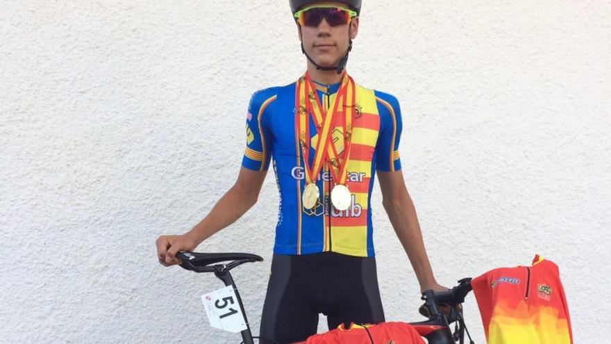 Juan Ayuso, vestido con el maillot de campeón autonómico, muestra los dos jerséis logrados en Ávila y las medallas de oro