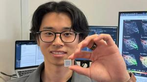 El autor principal y estudiante de doctorado, Ruomin Zhu, sostiene el chip que gestiona la red neuronal en su centro.