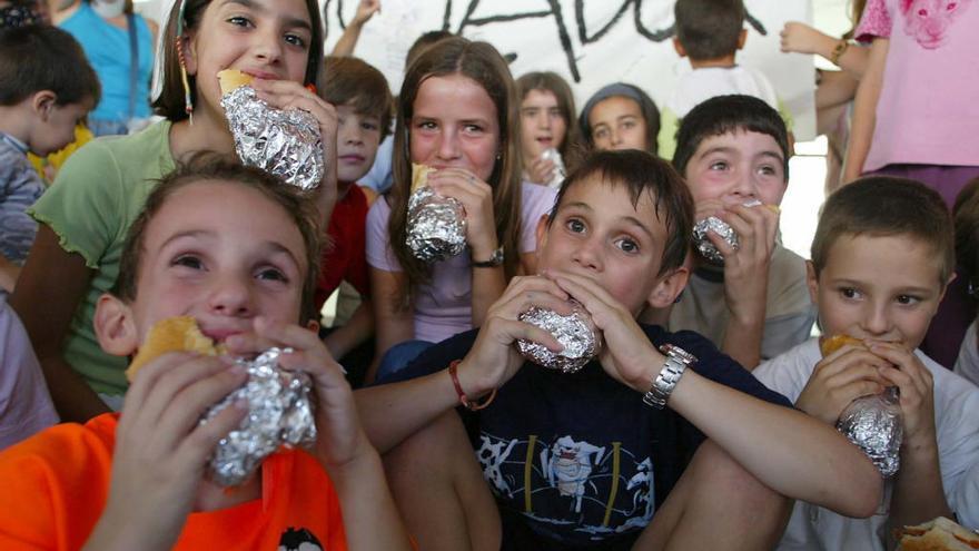 Escolares le hincan el diente a sus bocadillos, liados con papel de aluminio.