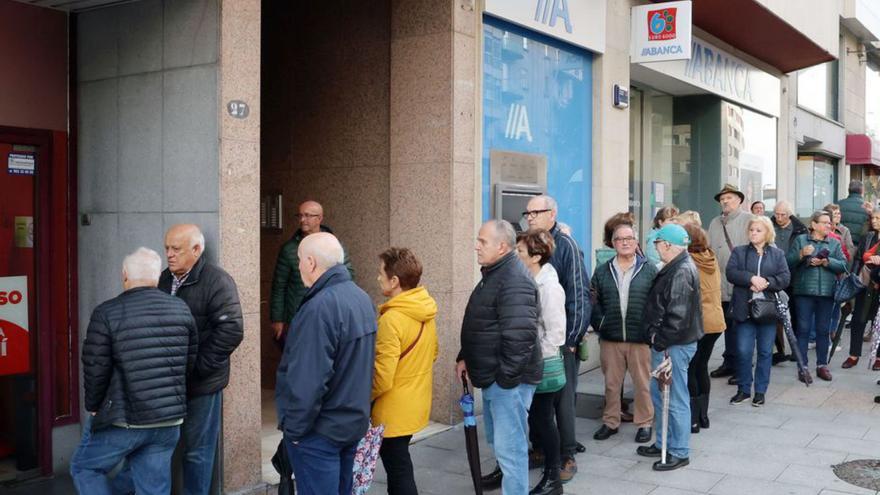 Mayores hacen cola en una agencia de viajes.