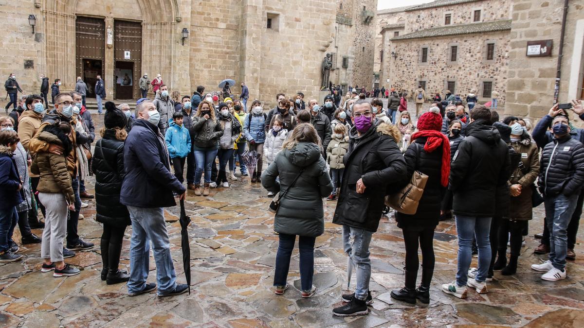 Un grupo de turistas en un visita guiada por la ciudad monumental de Cáceres, el pasado martes por la mañana, en la plaza de Santa María.
