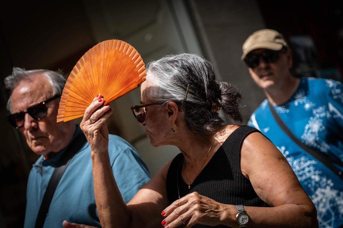 Una mujer se tapa del sol con su abanico durante una jornada de calor en Santa Cruz de Tenerife