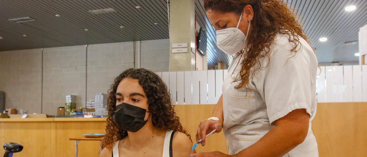 Una joven se vacuna en el recinto ferial de Fexdega