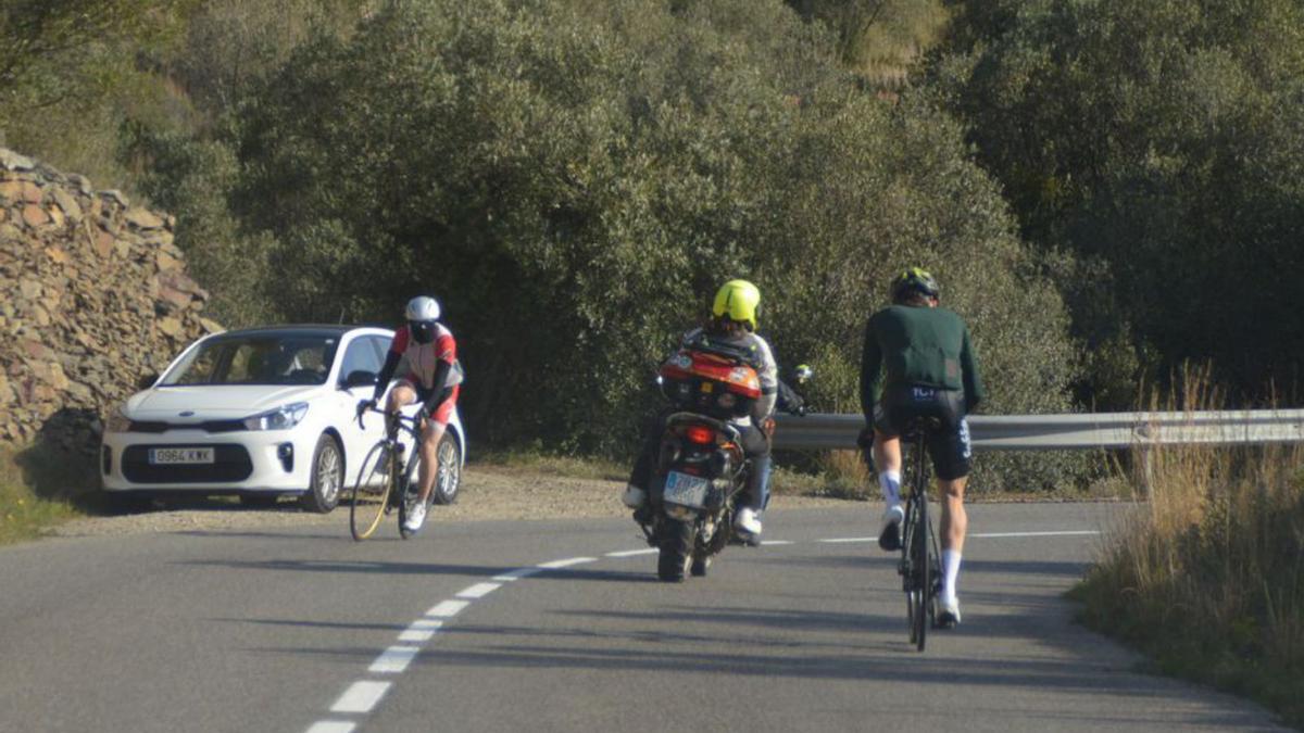 Dos ciclistes creuant-se a la carretera de Cadaqués.