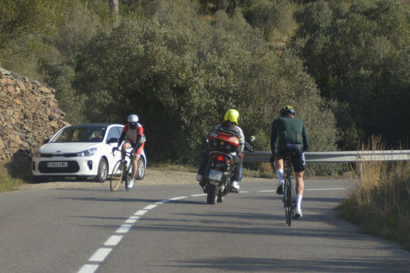 Dos ciclistes creuant-se a la carretera de Cadaqués.