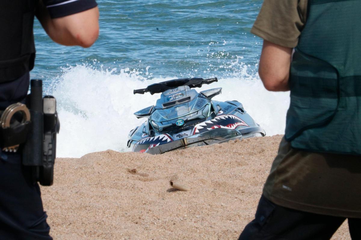 Policia i Guàrdia Civil custodiant la moto aquàtica.