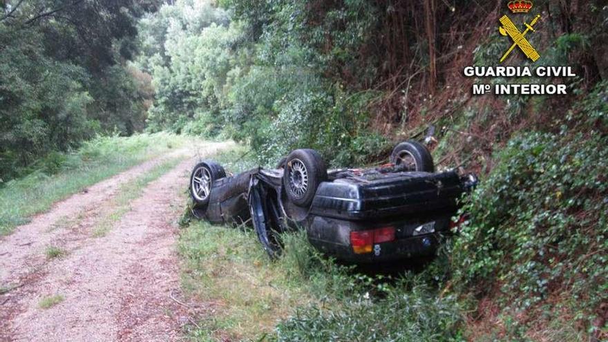 El coche que ocupaban el piloto y el herido grave quedó volcado tras el accidente. // Guardia Civil