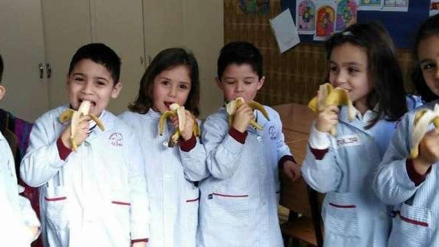 Niños del colegio riosellano con un plátano durante el recreo.