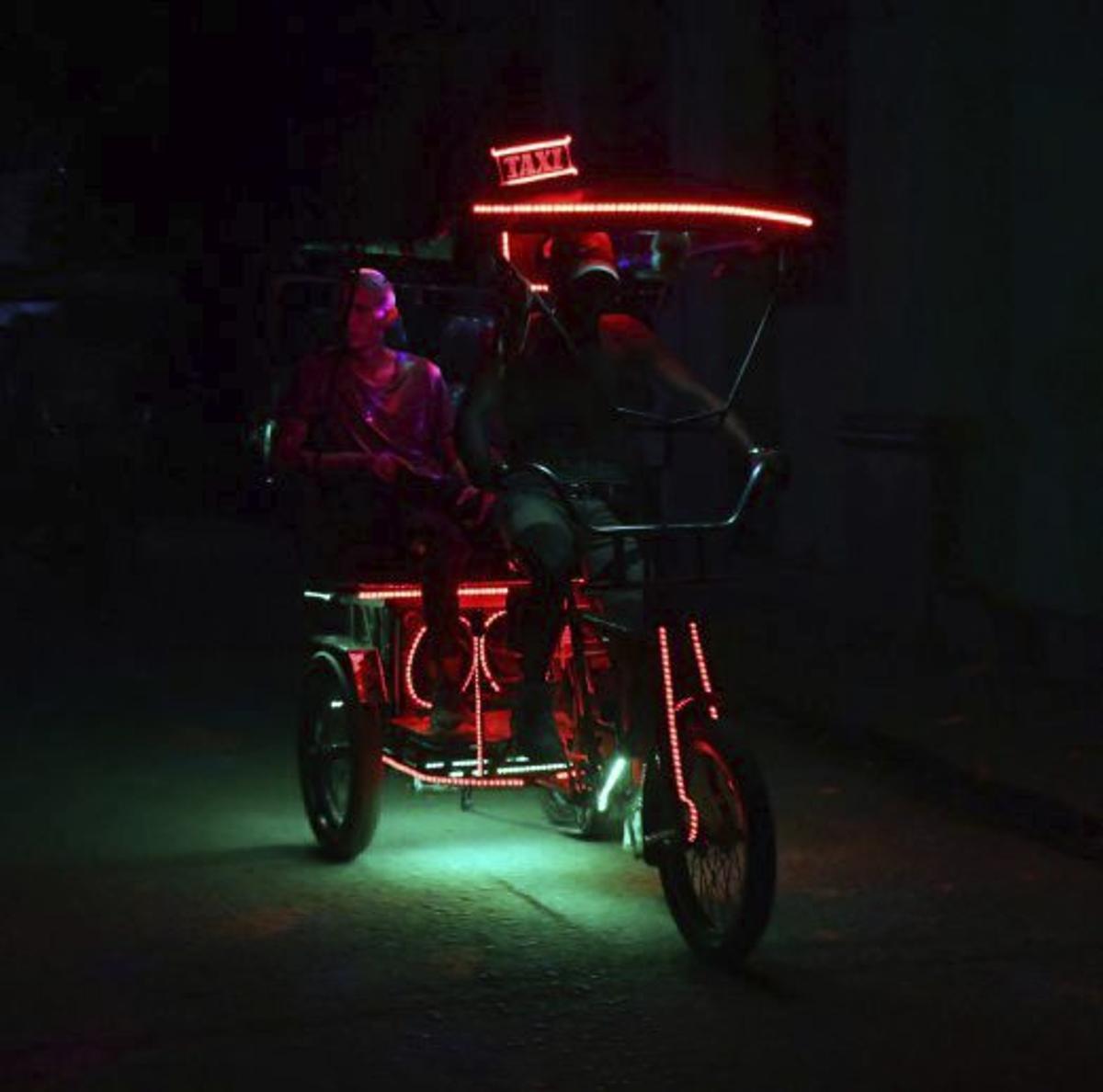Personas pedaleando una noche de apagón en Cuba.