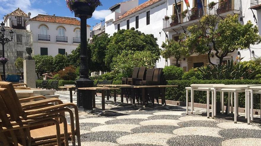 Mesas y sillas amontonadas de uno de los restaurantes ubicados en la plaza de Los Naranjos.