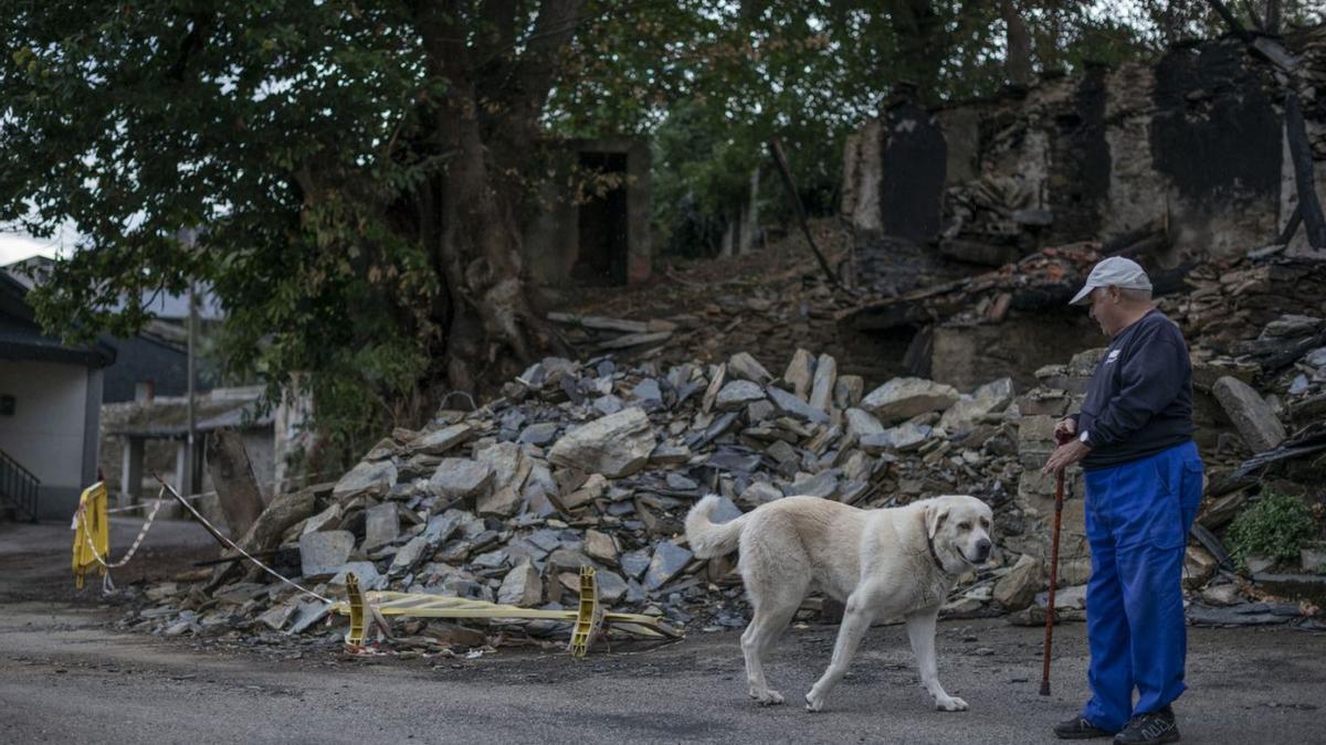 Uno de los vecinos pasea junto a unos escombros de lo que antes era una casa.   | // BRAIS LORENZO 