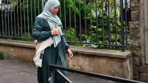Una mujer visitiendo una abaya en una calle de París.