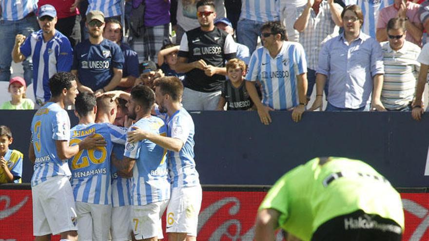 Los jugadores del Málaga se abrazan al fondo, con el portero rayista abatido.