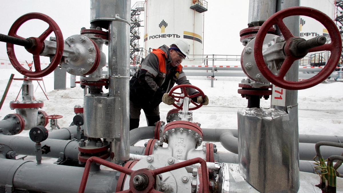 FILE PHOTO: A worker turns a valve at UdmurtNeft's Gremikhinskoye oil field east of Izhevsk