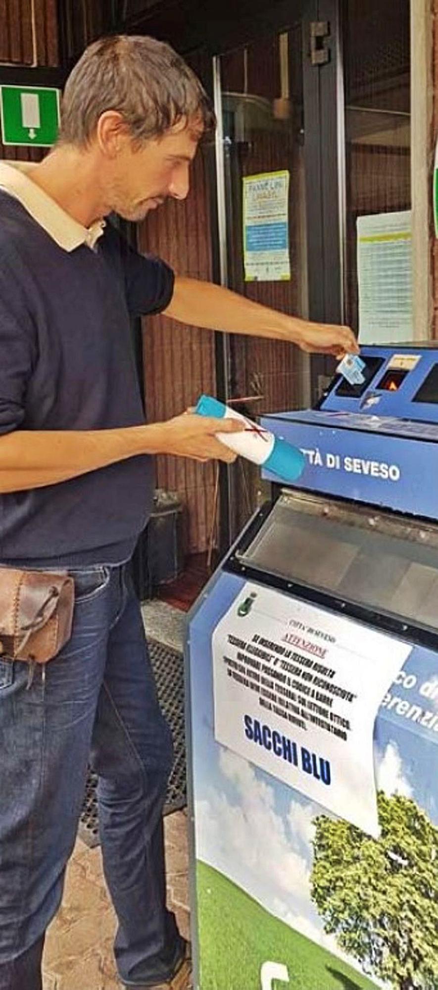 Un vecino de Seveso (Italia), ante una máquina de bolsas prepago de basura.