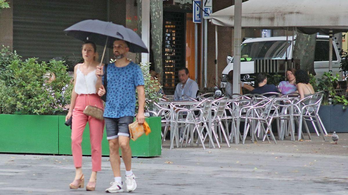 Una parella es passeja per Manresa durant un episodi de pluja