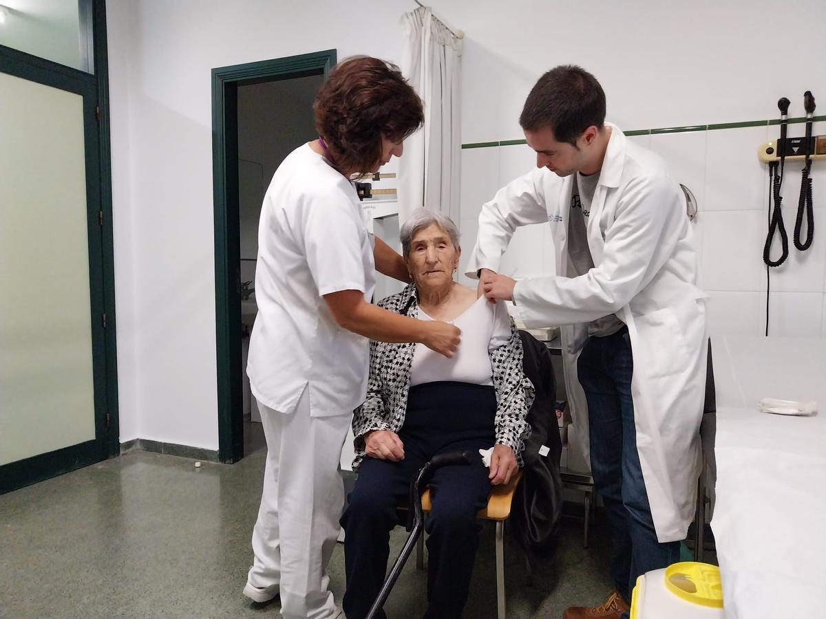 Sanitarios del centro de salud de Bueu vacunan a una mujer mayor en el primer día de la campaña.