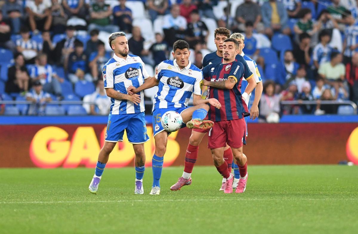 Loureiro controla el balón encimado por dos jugadores del Huesca en el partido de la primera vuelta en Riazor.