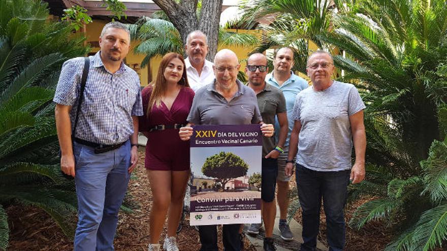 Parte de los organizadores del acto posan junto al cartel.