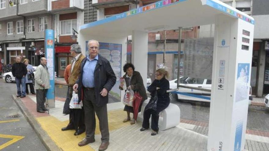 Usuarios del autobús, en la marquesina inaugurada ayer por Yoya Neira. / víctor echave