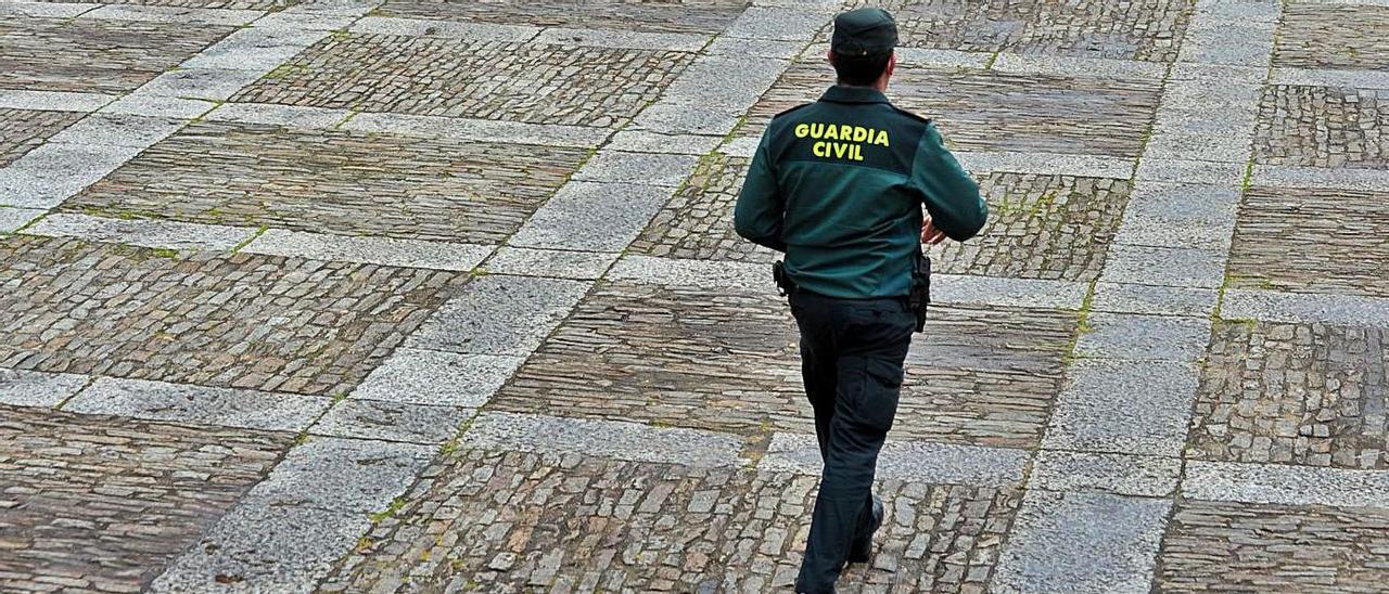 Un guardia civil camina ayer por la desértica Praza de Fefiñáns de Cambados.