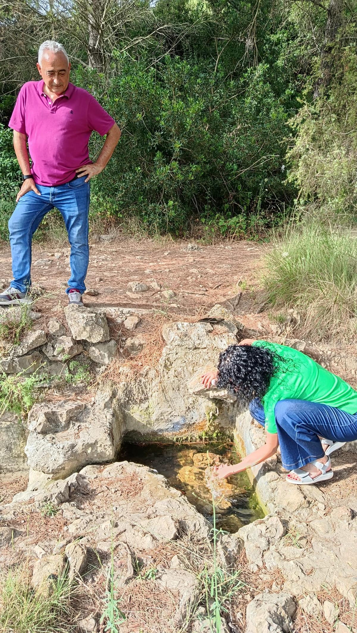 Romero y Cuñat comprueban el agua en una de las fuentes naturales.