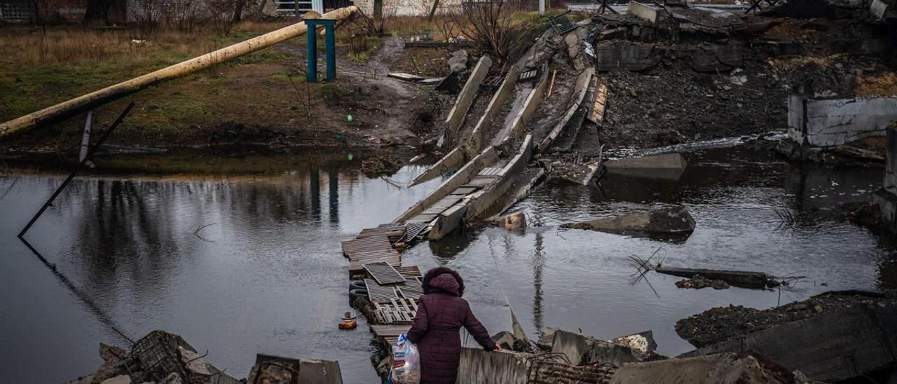 Una mujer cruza un puente destruido en Bajmut, región de Donetsk, el 6 de enero de 2023, en medio de la invasión rusa de Ucrania.