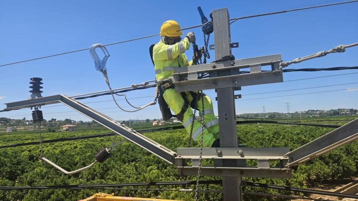 Un técnico trabaja en la instalación de catenaria en el tramo afectado por la dana.