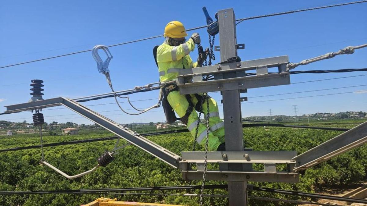 Un técnico trabaja en la instalación de catenaria en el tramo afectado por la dana.