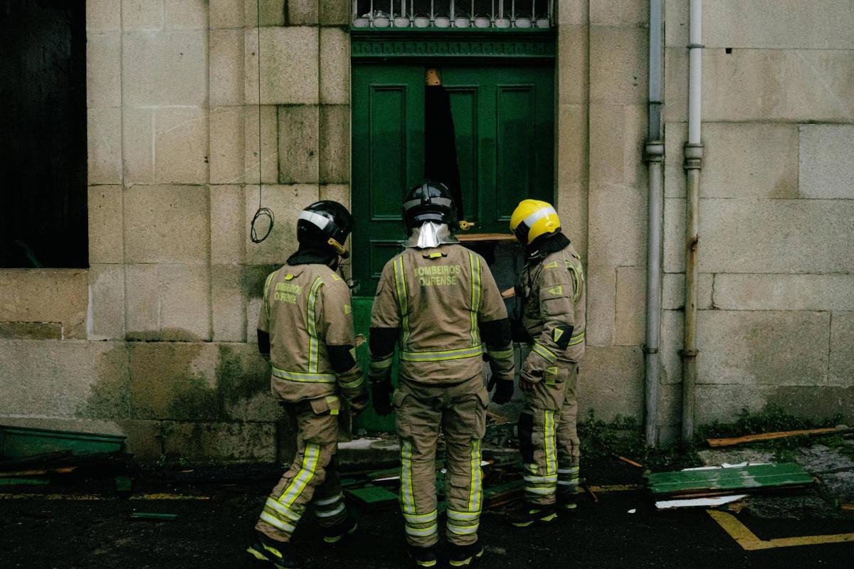 Los bomberos, este viernes por la mañana, horas después del incendio, ante una puerta que fue tapiada el jueves.