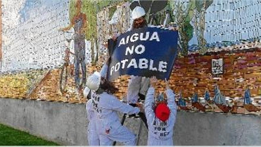 Els membres de Salvem col·locant un cartell al mural de la plaça Vila d&#039;Ordis.