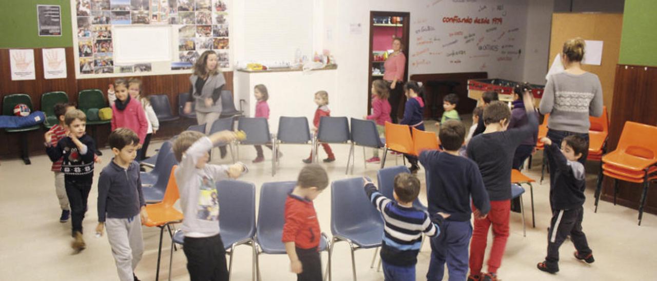 Los participantes en el campamento navideño y sus monitores juegan a las sillas musicales.