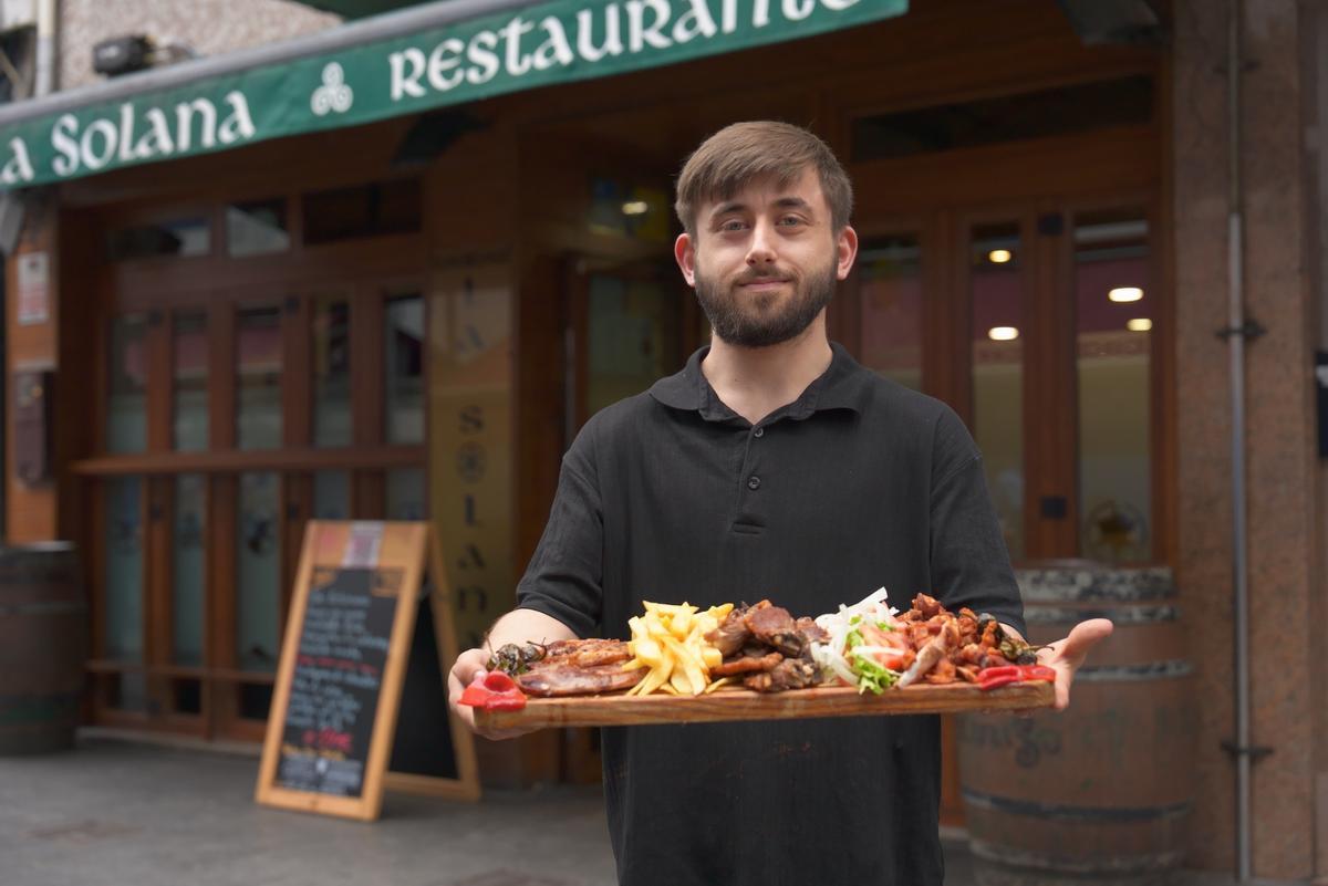 Un profesional, ofreciendo un plato de ternasco.