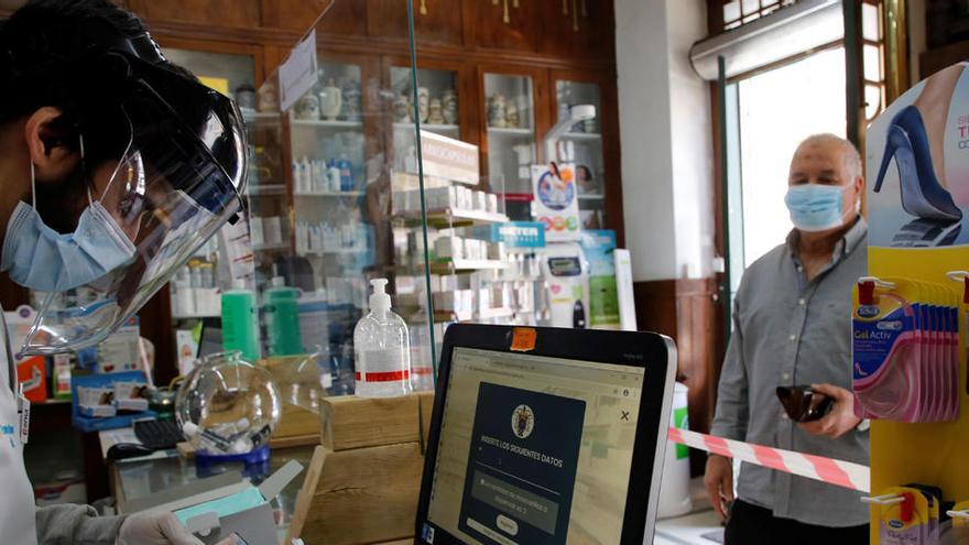 Un hombre recoge unas mascarillas en una farmacia