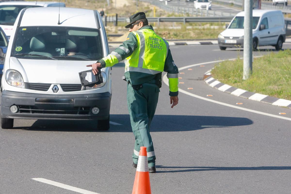 Un agente de la Guardia Civil de Tráfico  para a una furgoneta