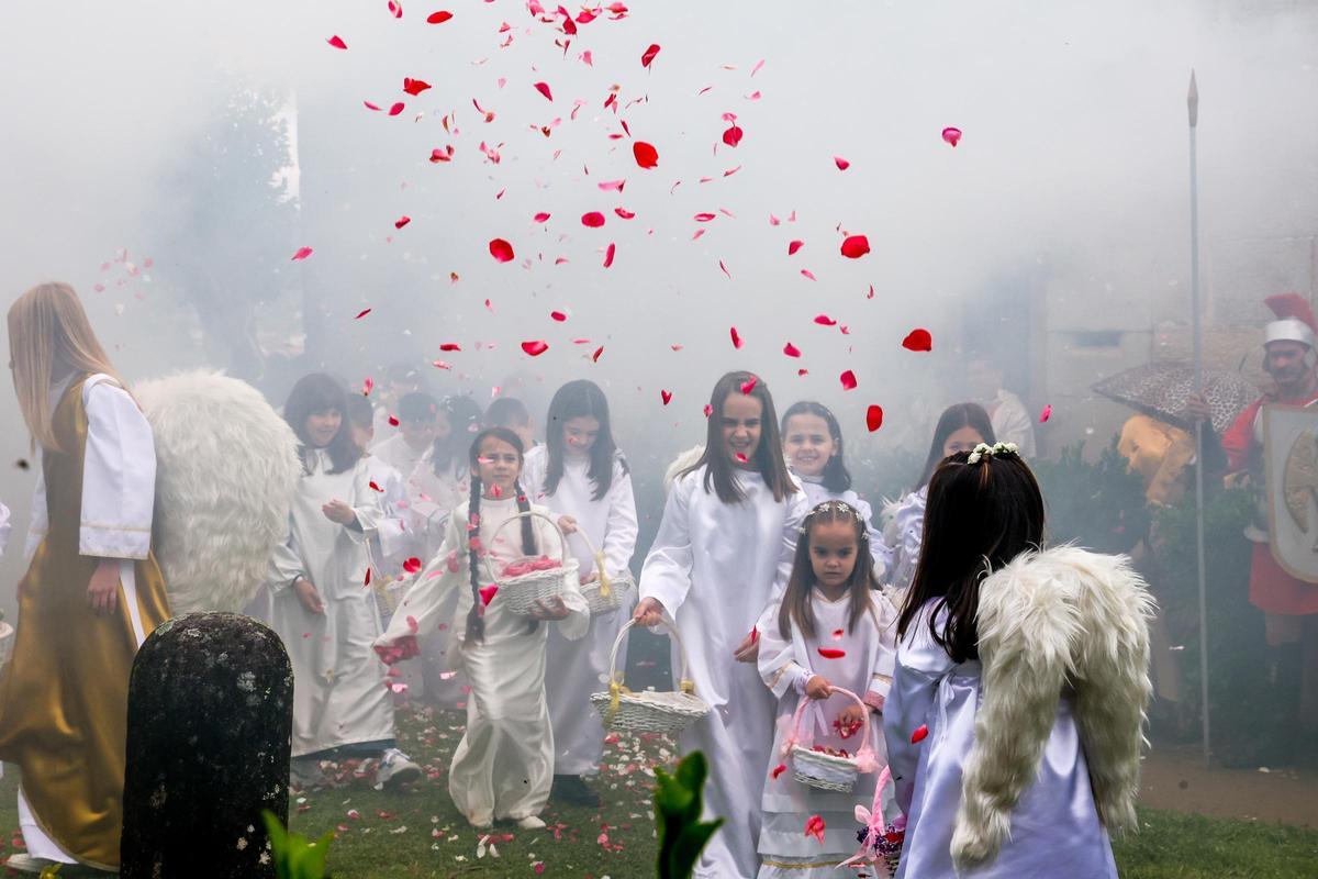 Un grupo de niñas lanzan pétalos al aire en la representación de la Resurrección.