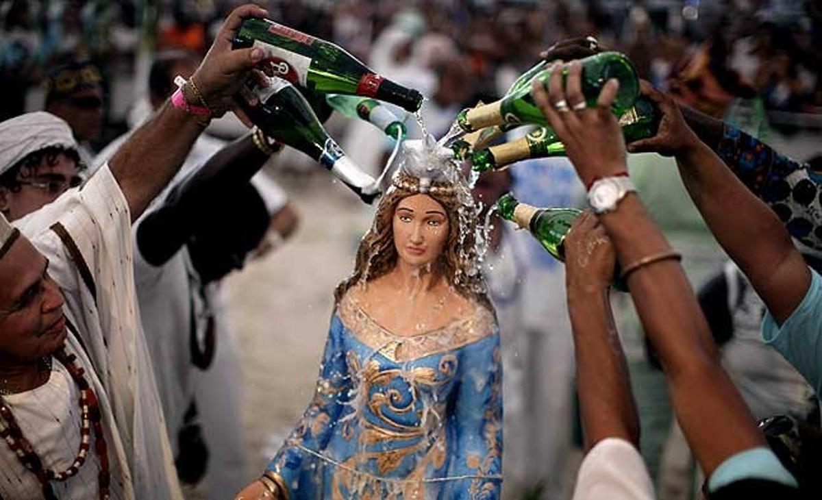 Fidels aboquen sidra a una estàtua de Yemanjá, la deessa del mar, durant una cerimònia que forma part de les celebracions tradicionals del Cap d’Any a la platja de Copacabana, a Rio de Janeiro (Brasil).