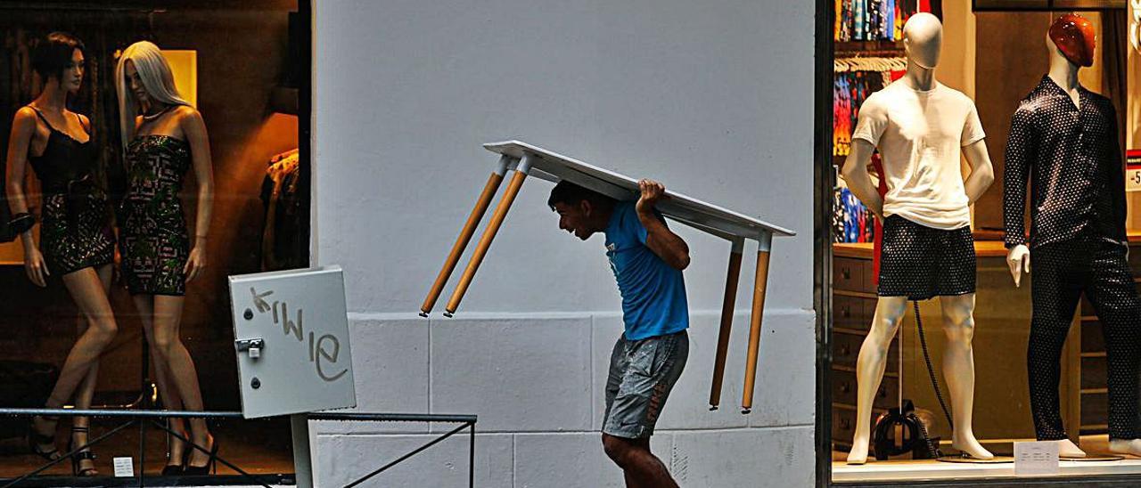 Un hombre utiliza una mesa para guarecerse. | TONI ESCOBAR