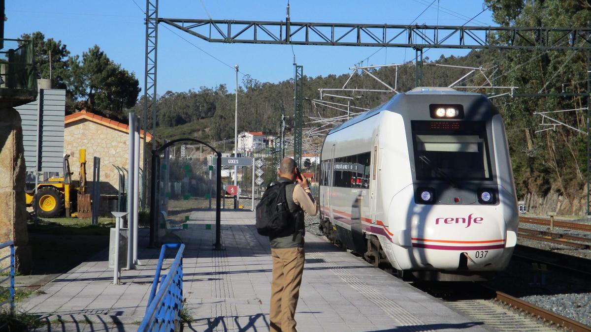 Un viajero espera la llegada del tren en la estación de Uxes, en Arteixo